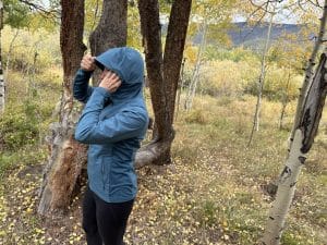 A women wearing the Arc'teryx Atom SL jacket in a Colorado alpine forest.