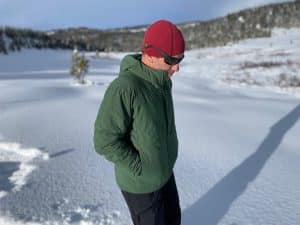 A man wearing the Arc'teryx Proton Heavyweight jacket in the snowy Colorado backcountry.