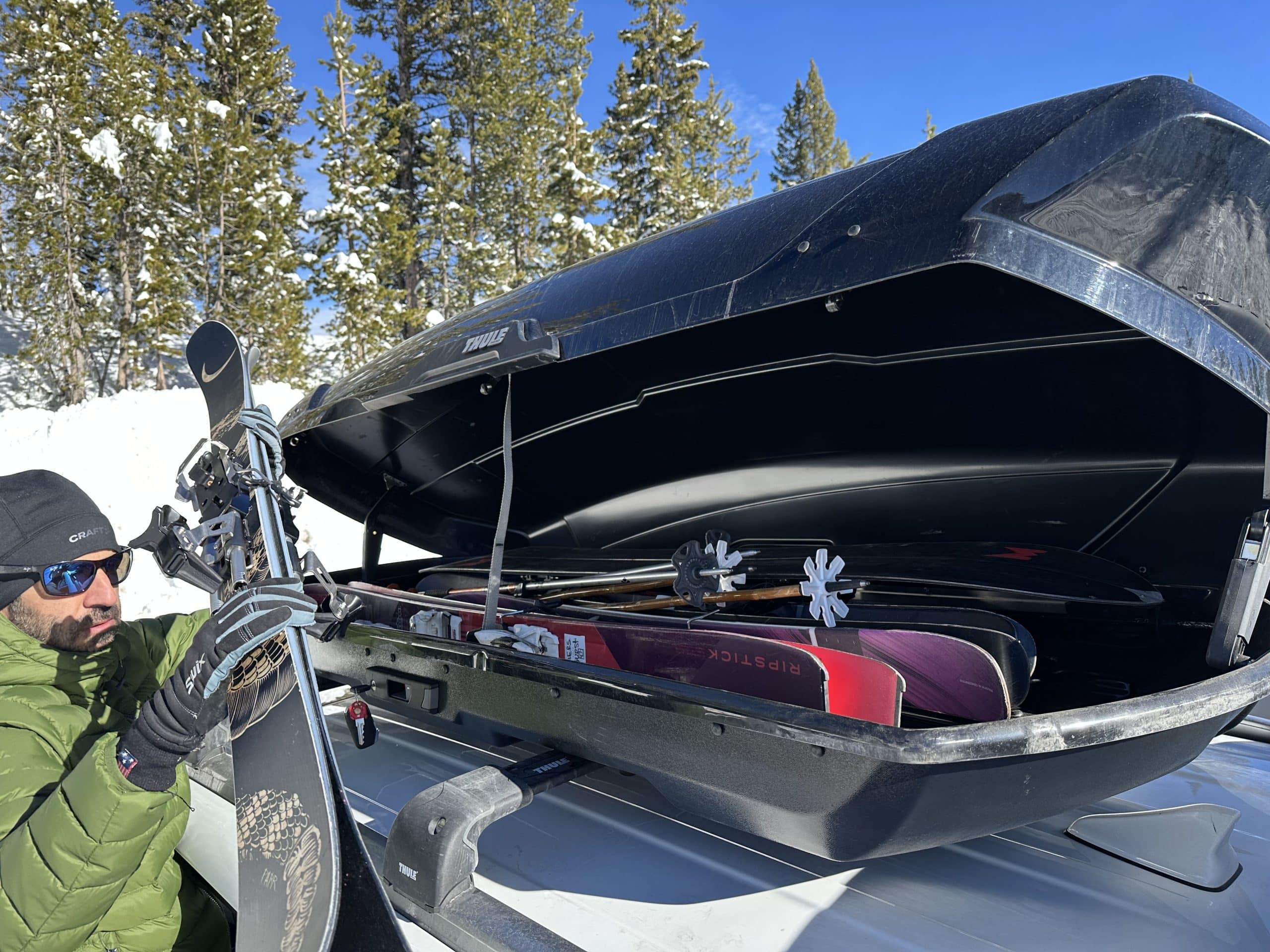 Thule-Motion-roof-cargo-box-loading-skis Thule Motion rooftop cargo box with skis and snowboards