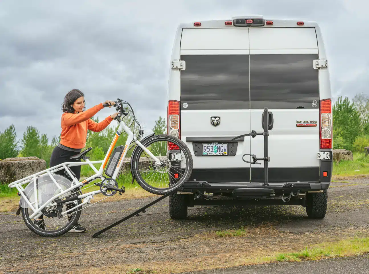A woman loading an eBike on the Yakima OnRamp LX bike hitch rack