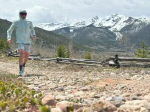 A man running in the mountains wearing the Arc'teryx Incendo Airshell Hoody.