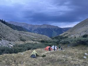 Ultralight backpacking tents pitched in the mountains with a stormy sky.