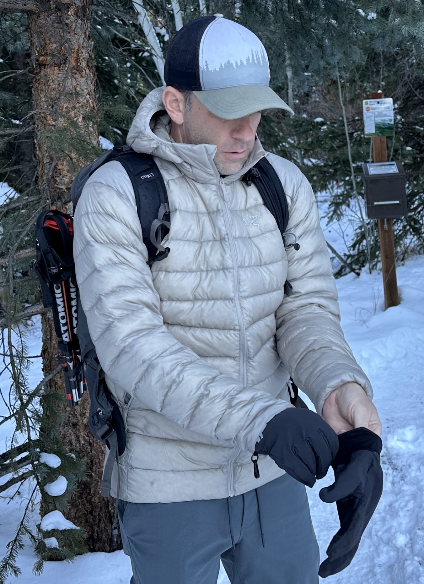 Man wearing the Arc'teryx Cerium lightweight down jacket on a winter hike.