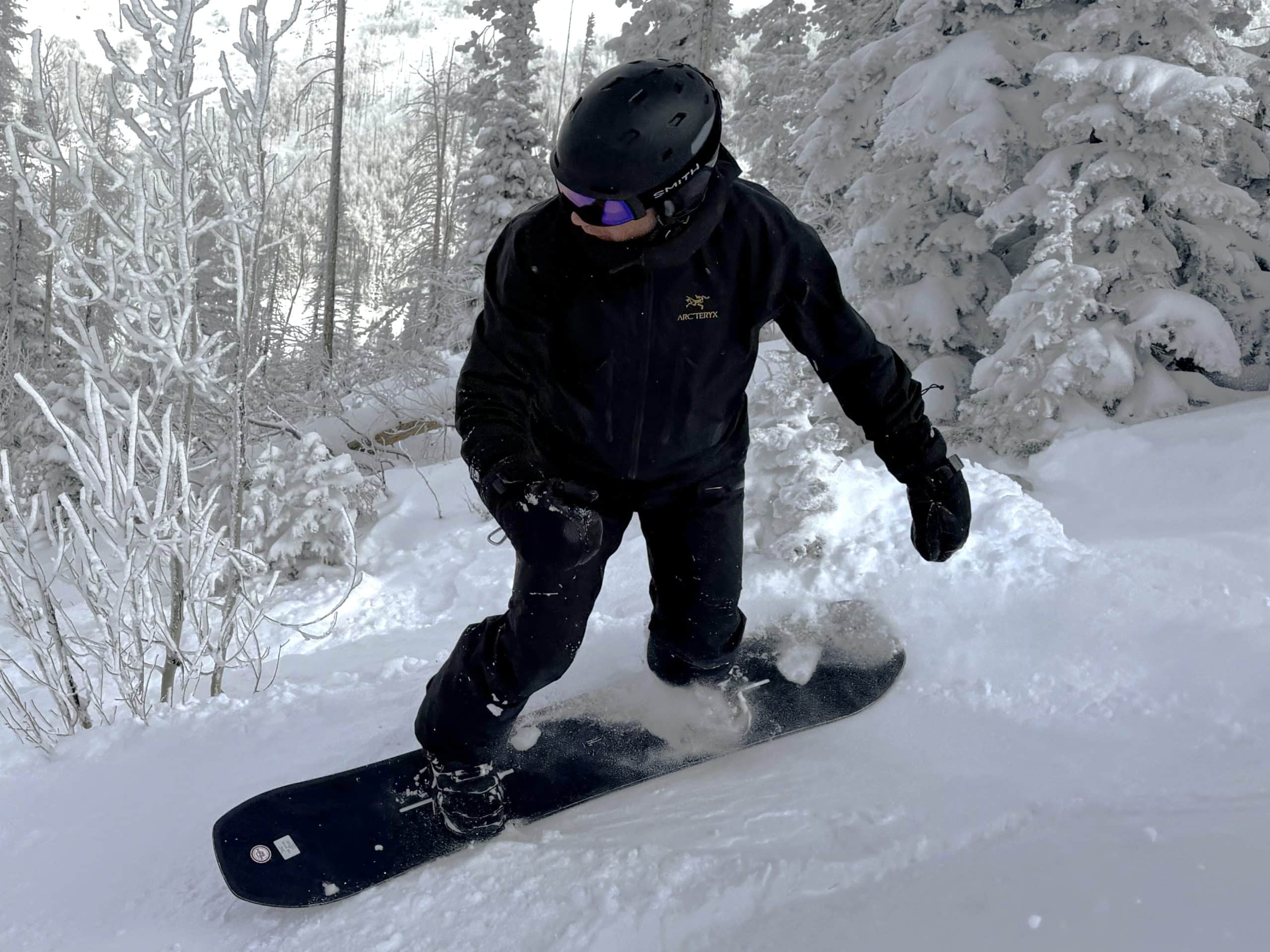 A snowboarder wearing the Arc'teryx Alpha SV jacket.