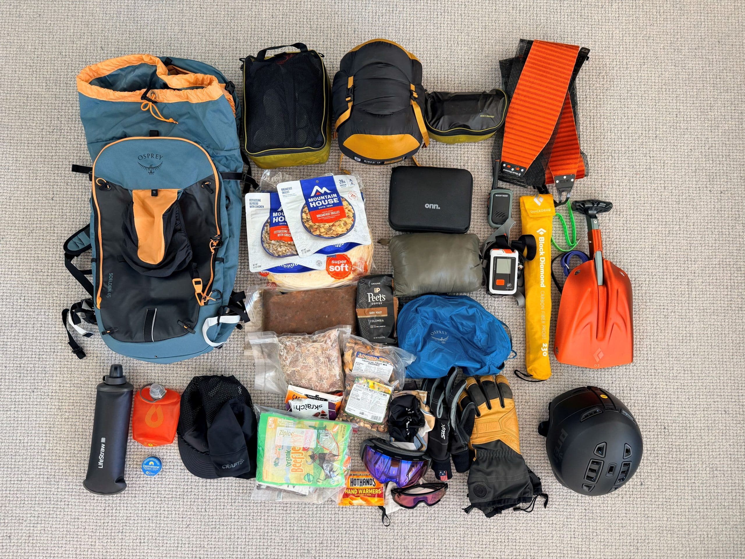 The Osprey Soelden 45L ski backpack along with everything that was packed inside for a 3-night backcountry ski trip.