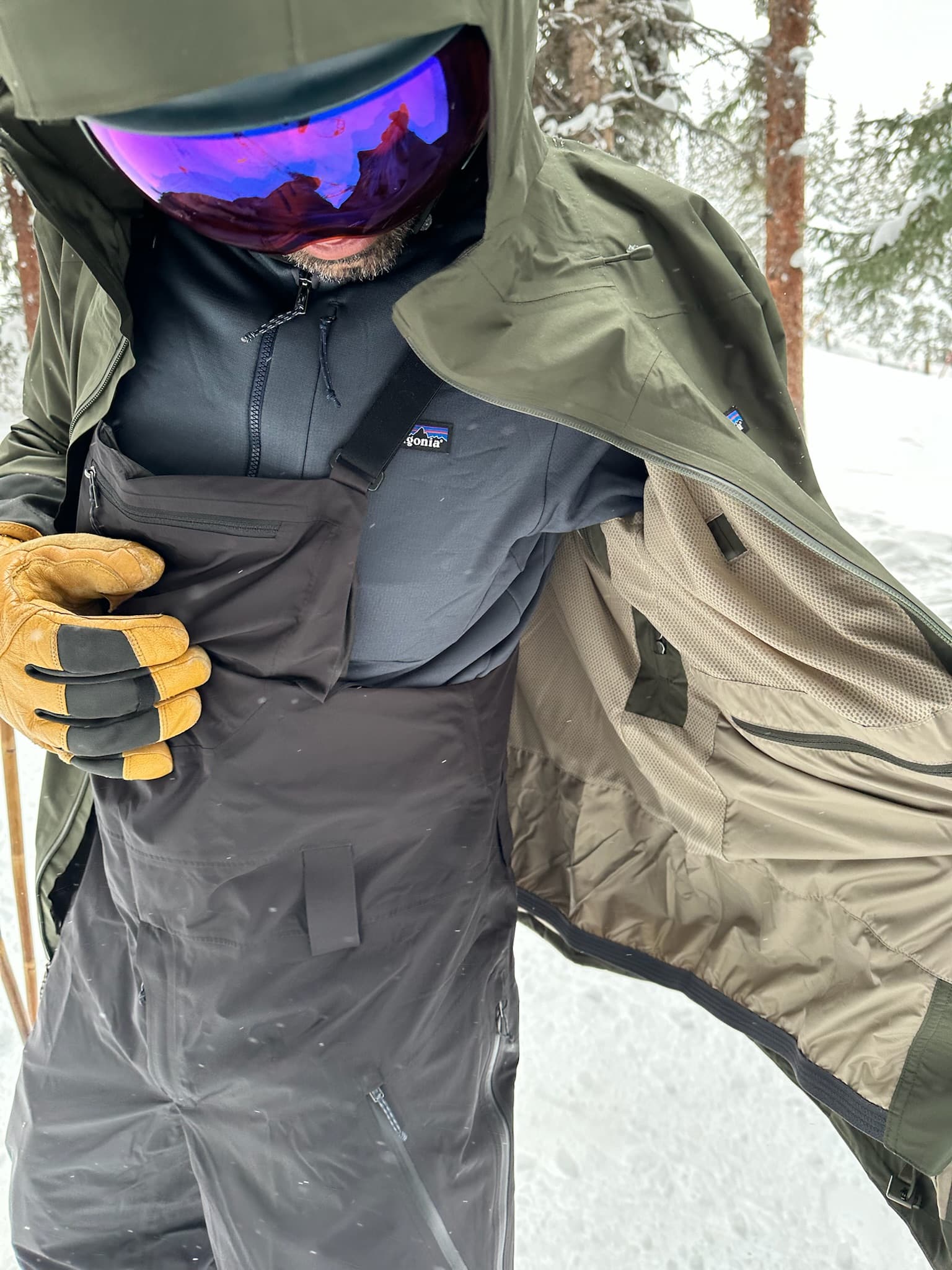 A skier showing the inside of his Patagonia Powder Town jacket.